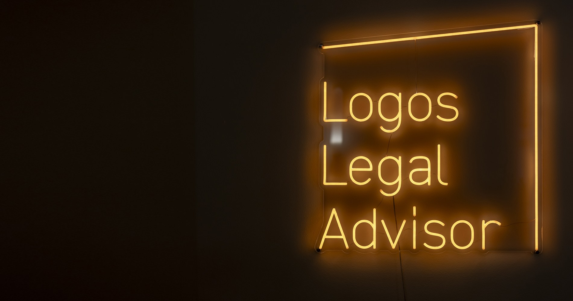 Leuchtschrift Logos Legal Advisor am Empfang der Kanzlei
